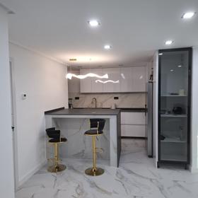 Kitchen in the same flat, opened onto the living room, with a peninsula and bar stools