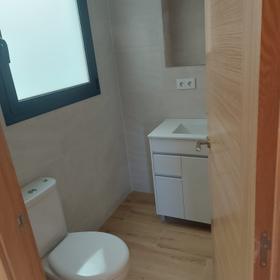 Bathroom in the same flat, with a two-drawer white vanity