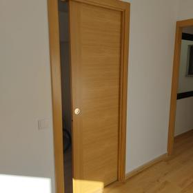 Oak pocket door sliding into the partition